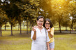 © gballgiggs - Couple asian woman hands showing mini heart and relax at public park in the morning together,Happy and smiling,Positive thinking,Healthy and lifestyle concept