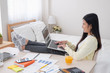 © weedezign - Asian female freelancer working on laptop computer on table at bedroom at home.working online lifestyle.work at home.