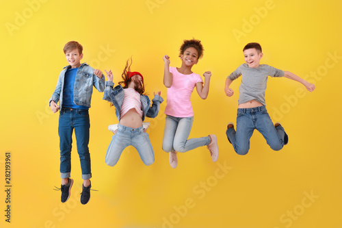 Fotomural Jumping children in jeans near color wall