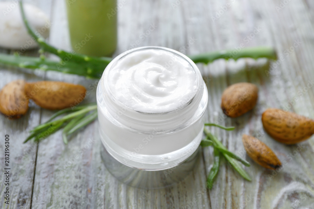 Jar of natural cream on wooden background