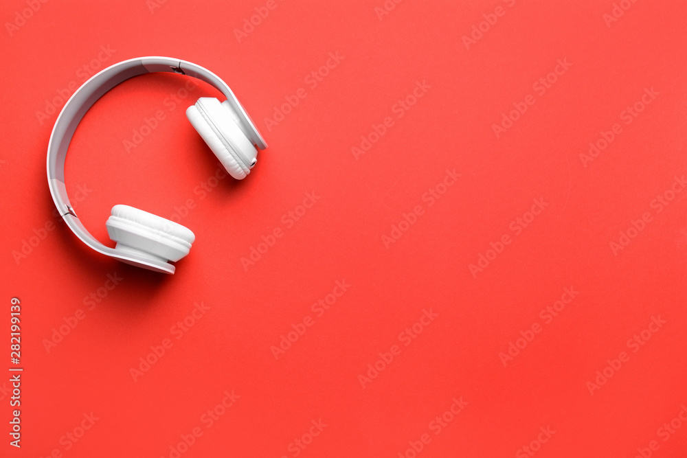 Modern headphones on color background