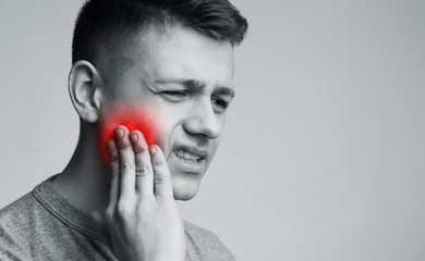 Man suffering from strong tooth pain, monochrome photo