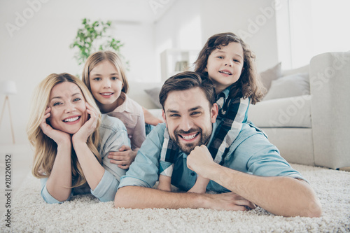 Fotografía Photo of four members adopted family lying floor toothy smiling fluffy carpet co