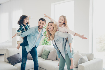 Profile photo of four family members having best leisure time pretend flight airplane indoors apartments