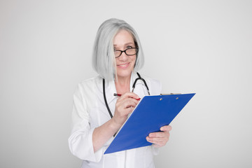 Portrait of happy professional female worker standing in a studio with stethoscope on her neck