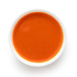 Peri peri chilli sauce in a white ceramic bowl isolated on white from above.