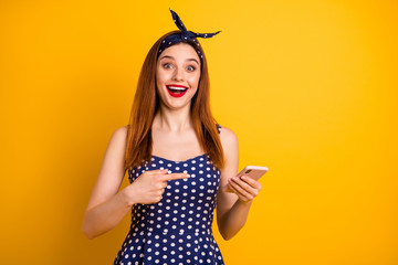 Canvas Print - Portrait of nice-looking attractive lovely girlish pretty cheerful glad amazed straight-haired girl holding in hand gadget showing incredible news isolated on bright vivid shine yellow background