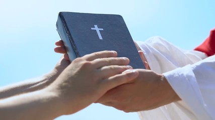 Poster - Male hands taking Bible from priest in robe, spread of Christian doctrine