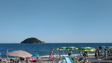 Albenga, Liguria, Italy. July 2019. Gallinara Island Is A Landmark On The Beaches Around Albenga. Its Unmistakable Shape Resembles A Large Tortoise. People Can Enjoy The View. 25 Fps Tilt Movement.