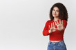 © Cookie Studio - No thanks. Reluctant awkward displeased young stylish girl curly dark hair step back waving hands disapproval rejection, refusing disgusting uninteresting idea frowning cringing bothered