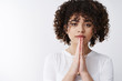 © Cookie Studio - Please beg you. Serious-looking tender young alluring curly hair girl press palms together supplication pray gesture asking pleading help need offer, hope friend land hand, standing white background
