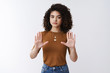 © Cookie Studio - Hold on, not come closer. Serious-looking empowered stylish yong modern female femenist curly dark hair lgbt supporter raise hands stop enough gesture confidently refuse give rejection