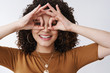 © Cookie Studio - Close-up silly carefree playful charming curly-haired girl show mask gesture hold fingers eyes as goggles smiling broadly laughing enjoy warm awesome summer sunny days standing white background