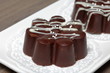 © f2014vad - Chocolate dessert in the shape of a flower. Dark chocolate coated. Garnished with white chocolate and sprinkles.