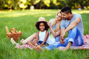 Wall Mural - Picture of lovely couple with their daughter having picnic