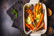 © vaaseenaa - Baked vegetables with thyme in the oven dish, dark background.