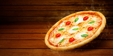 Pizza in flying on wooden table. Concept promotional flyer and poster for Restaurants or pizzerias, template with hot delicious pizza margarita closeup with steam smoke, tasty mozzarella cheese