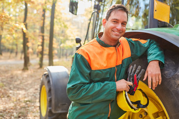 Wall Mural - Content forest worker is leaning against the forwarder