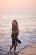 © polinaloves - Pregnant woman beauty with long hair walking at the beach.