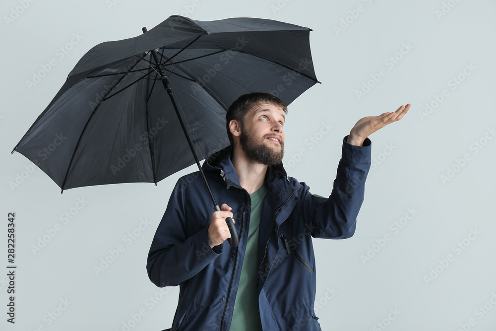 Handsome man with umbrella on white background