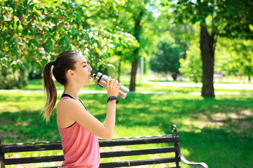 Sticker - Sporty young woman drinking water after training outdoors