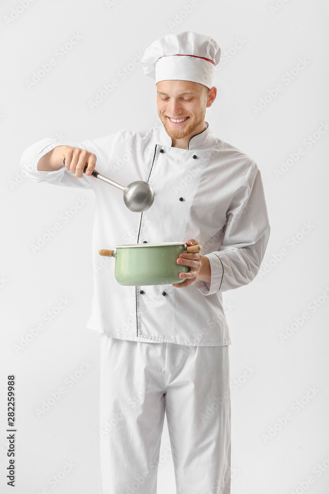 Handsome male chef with soup on white background