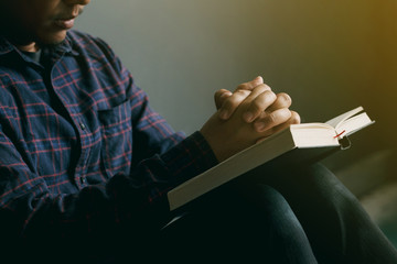 Man praying on holy bible in the morning.teenager boy hand with Bible praying,Christians and Bible study concept.copy space.praying for Get out of the coronavirus crisis