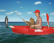 The Fisherman With His Cat Is Fishing On The Red Plastic Boat In The Sea. They Caught A Big Fish.