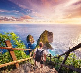 Wall Mural - traveler look at the ocean and rocks. travel and active life concept. adventure and travel on bali, 