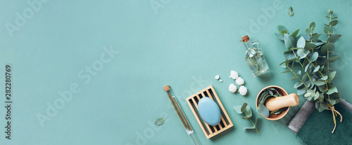 Fotografía Soap, eucalyptus, towels, massage brush, salt, aroma oil and other spa objects on green background