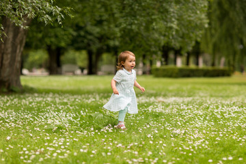 childhood, leisure and people concept - happy little baby girl running at park in summer