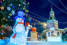 Moscow, Russia. Christmas Decoration Snowman And Tree On The Background Of The Kremlin. Fair On Red Square In Christmas. Christmas Decoration Of The Red Square.