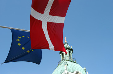 Fragments of the flag of Denmark and the flag of the European Union against the backdrop of the dome of the cathedral and the blue sky.