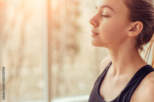 Cuadros en Lienzo Young woman doing breathing exercise