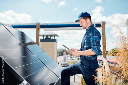Cuadros en Lienzo Young master with tablet searching for online data about solar panels