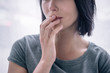 © LIGHTFIELD STUDIOS - Cropped view of lonely woman covering mouth at home