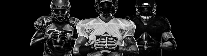 Wall Mural - American football player, sportsman in helmet on dark background. Black and white photo. Sport wallpaper.