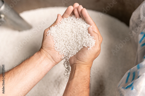 Fotografía View of modern factory worker hands holding pile of white polymer pellets