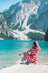 Wall Mural - woman sitting on the beach of mountain lake summer season