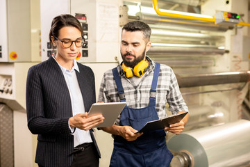 two young engineers testing new system of quality control in chemical factory