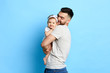 © the faces - caring best daddy hugging his daughter, expressing love. isolated blue background. studioshot.