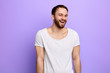 © the faces - smiling, laughing young man with white t-shirt looking at the camera. isolated blue background. stduio shot. happiness, emotion and feeling, facial expression