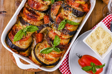 Traditional italian food. Baked eggplant, tomatoes with sauce, parmesan and basil. Rustic food for a healthy diet. Vegetables for lunch.