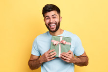 Handsome Bearded Overjoyed Man Wearing Casual Clothes Holding Present Box Standing Isolated Over Yellow Background,Birthday Party. Celebration, Happiness, Best Present From Girlfriend