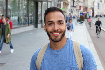 Handsome ethnic young male smiling outdoors