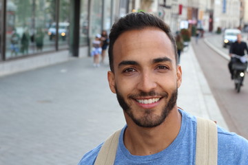 Handsome ethnic young male smiling outdoors