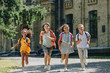 © LIGHTFIELD STUDIOS - four happy multiethnic schoolchildren smiling while running in schoolyard