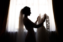 Bride Holding White Wedding Dress With Lace, Embroidery. Bride Getting Ready
