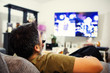 © Jopstock - Relaxing Man Lying on Couch watching tv and Holding a Tv Controller