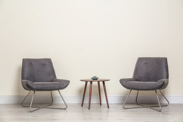 Poster - room interior with modern chairs and table near light wall